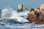 blue sea and rocks storming in light of sunset